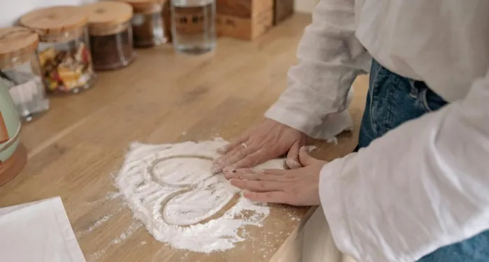 a photo of someone drawing a heart in flour